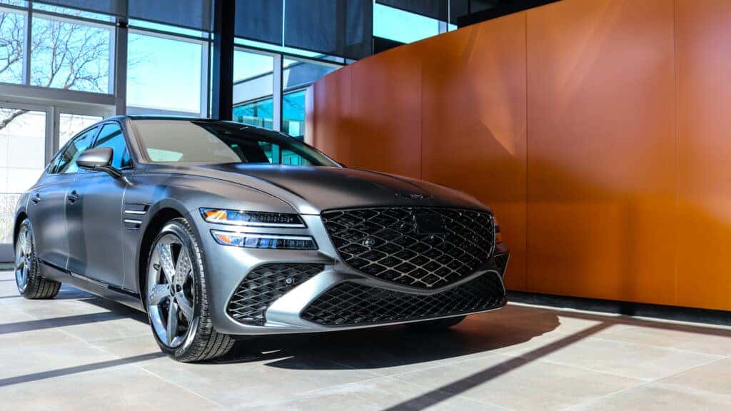 Side and front view of the 2026 Genesis G80 showcasing its sleek, modern design, sculpted body lines, and luxury styling.