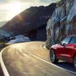 red 2019 jaguar f-pace driving on mountain highway