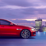 Red Jaguar XE against city skyline