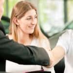 Man shakes dealers hand after buying a car