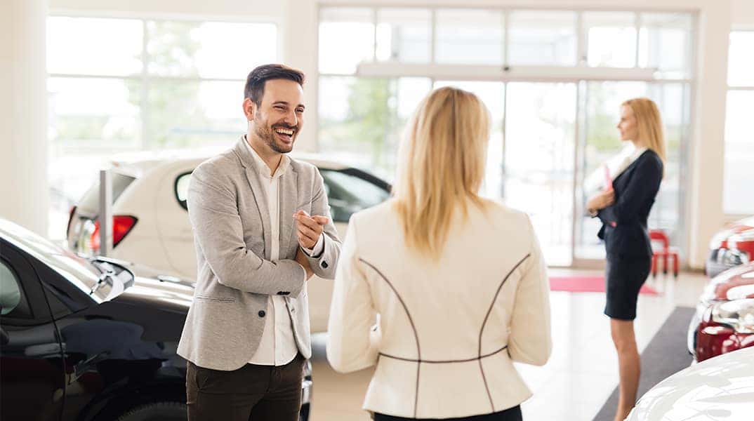 Lancaster Toyota is a Car Dealership in Lancaster near Cornwall PA | Customer and Sales Advisor Talking While in Vehicle Showroom
