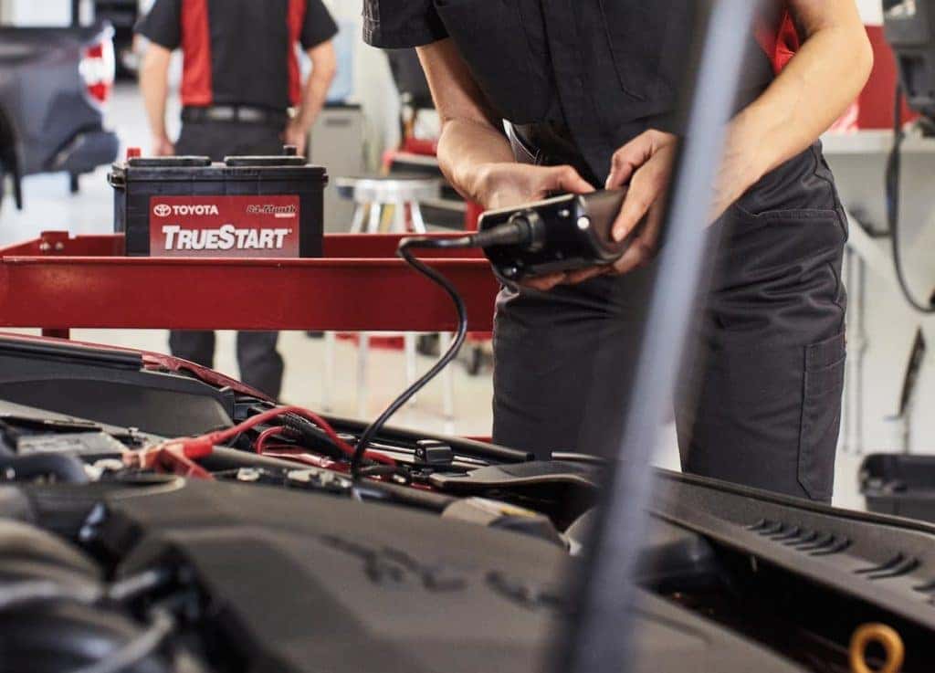 Lancaster Toyota is a Car Dealership in Lancaster near Farmdale, PA | Toyota service technician checking battery on Toyota vehicle