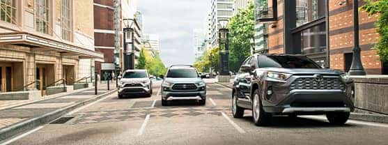 Compare the 2021 Toyota RAV4 vs. the 2021 Toyota Venza at Lancaster Toyota | Three RAV4's driving on city street