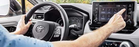 Compare the 2021 Toyota RAV4 vs. the 2021 Nissan Rogue at Lancaster Toyota | Pushing touch screen