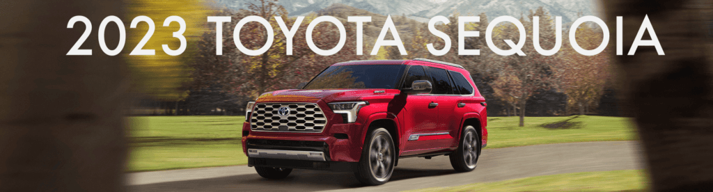2023 Toyota Sequoia at Lancaster Toyota in East Petersburg, PA | Red 2023 Toyota Sequoia driving through a park road with white text over it reading '2023 Toyota Sequoia'