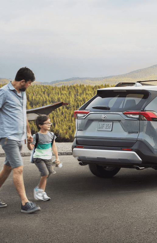 Accessories that help keep your Toyota protected at Lancaster Toyota in East Petersburg, PA | Father and son walking by their parked 2023 Toyota RAV4