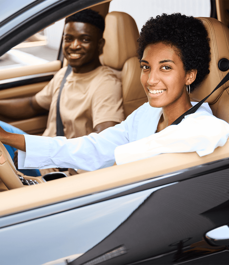 Defining GAP Insurance at Lancaster Toyota in East Petersburg, PA | Two people smiling sitting in the front row of a new car