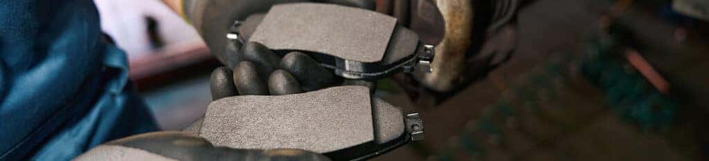 Brake replacement and Safety at Lancaster Toyota | Mechanic holding new brake pads