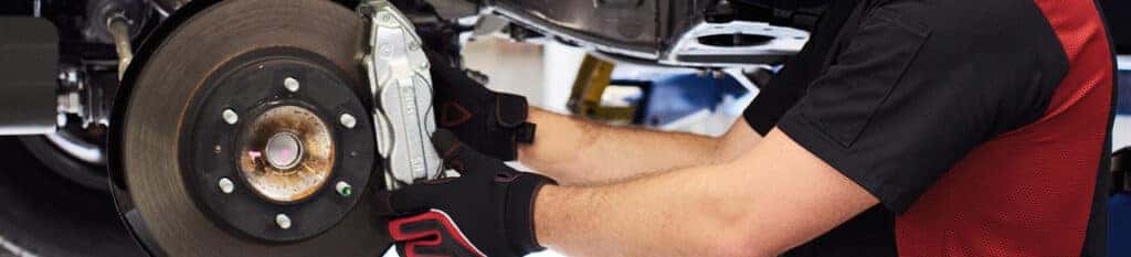 Brake replacement and Safety at Lancaster Toyota | Mechanic installing new brake pads onto brake rotor
