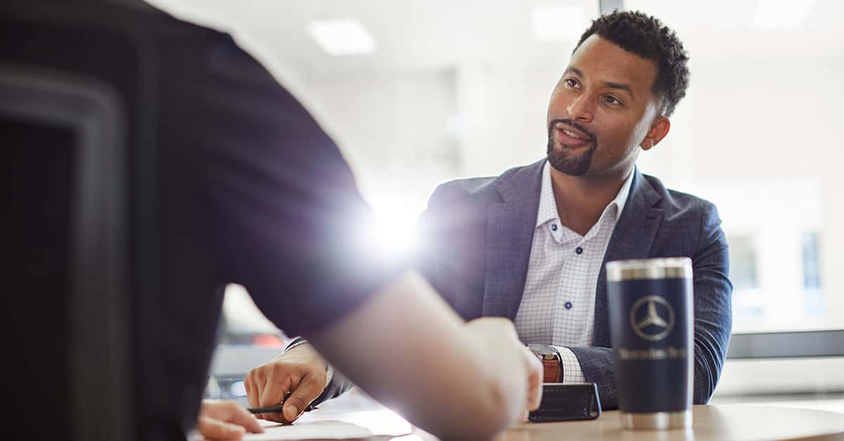 Customer speaking to a salesperson at a Mercedes-Benz dealership