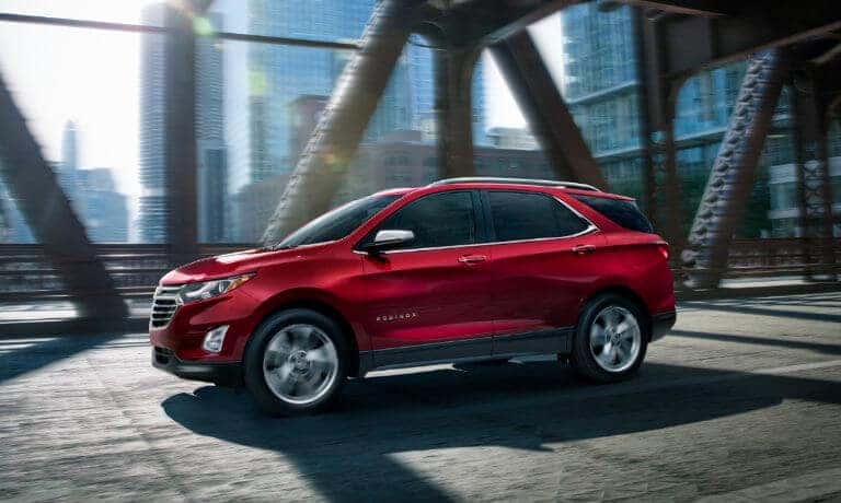 2020 Chevy Equinox in red driving over bridge in the city