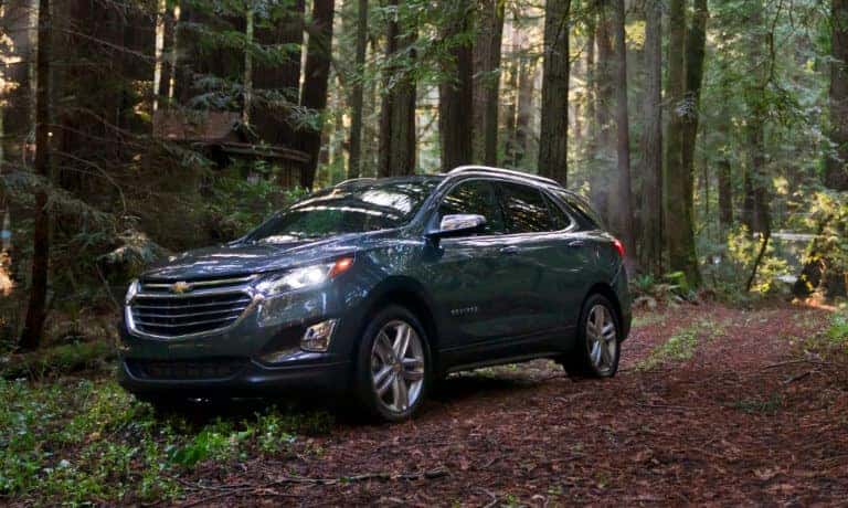 2020 Chevy Equinox in blue Driving off road throughout a forest
