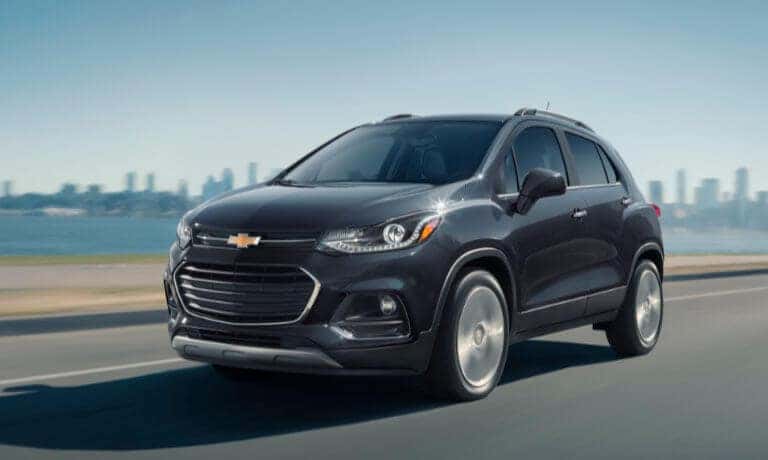 2020 Chevy Trax in black driving on highway with city in the background