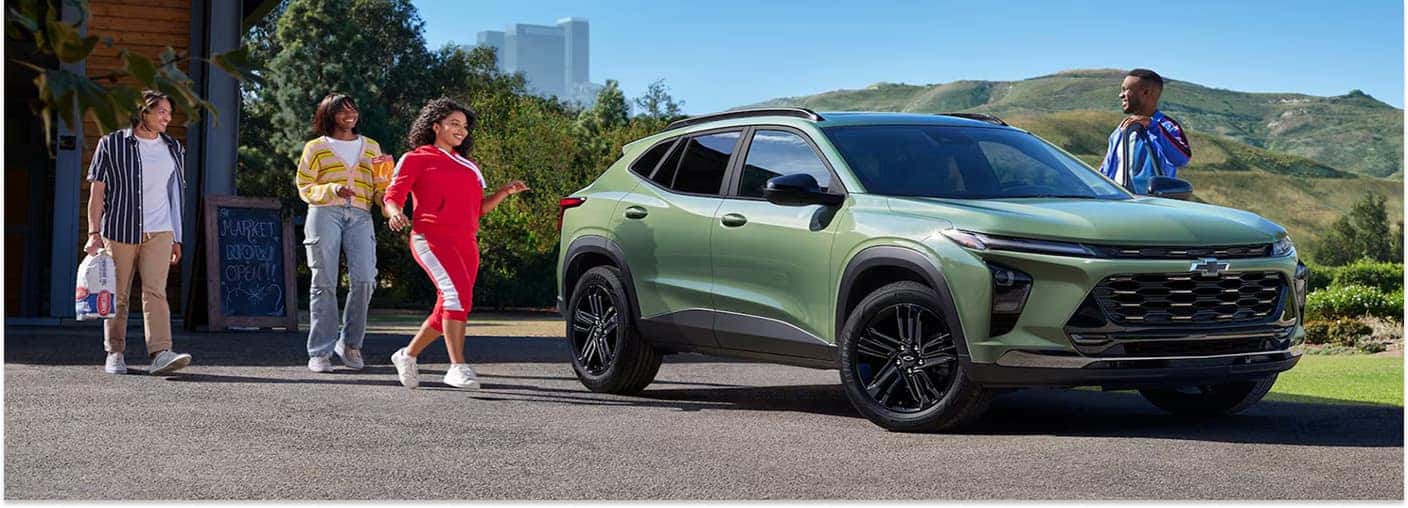 Green 2026 Chevrolet Trax Parked Alongside Group of Young Adults