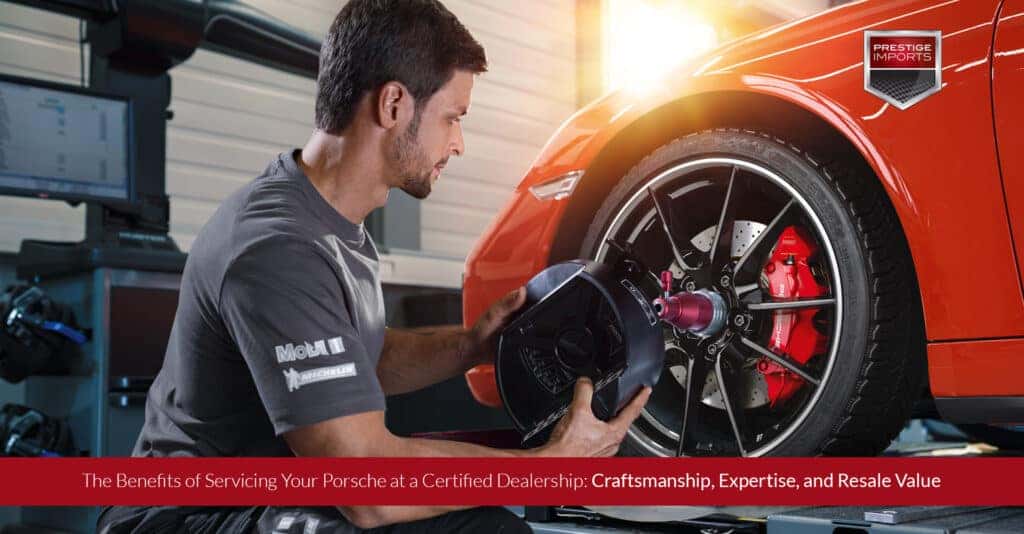 Certified Porsche Technician working on the wheel of a sports car. Certified Porsche Technician working on the wheel of a sports car.
