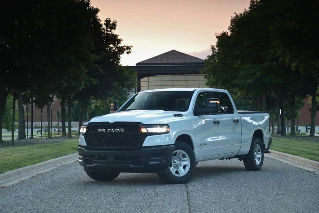 A 2025 Ram 1500 parked in front of a modern building, showcasing its sleek design and robust presence.