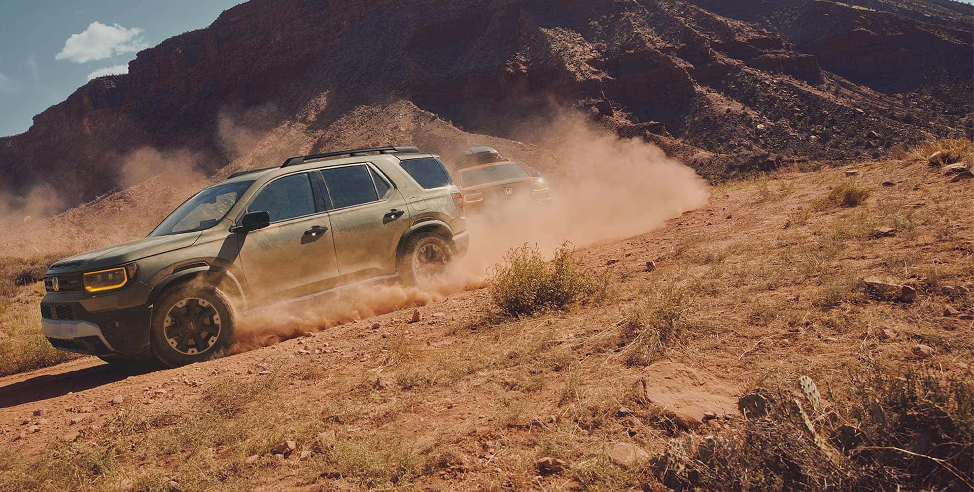 Blue Honda Pilot driving on a buddy road