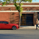 2024 Hyundai Elantra Limited with the Ultimate Red Exterior parked in front a brick building