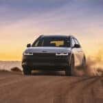 A 2025 IONIQ 5 XRT navigating a rugged dirt road, showcasing its versatility and off-road capability.