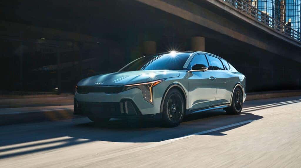 The all-new 2025 KIA K4 compact sedan displayed prominently, showcasing its modern design and innovative features.