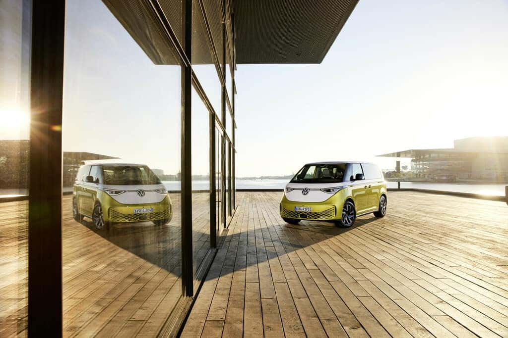 Green volkswagen Id.Buzz Bus Boardwalk building Ocean