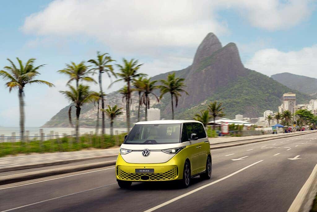 Green Volkswagen ID.Buzz EV Van Blue Sky Open Road Green Trees