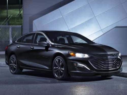 2024 Chevrolet Malibu Midnight Edition parked outside a modern building at night
