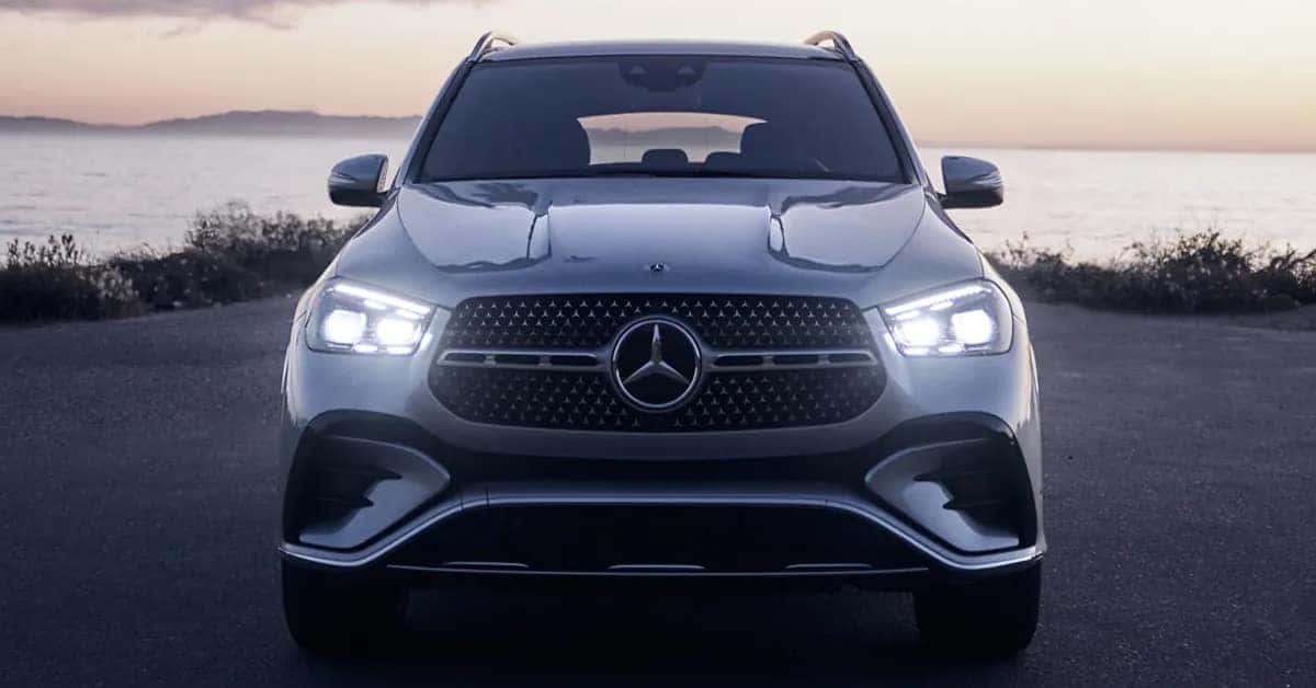 A silver 2026 Mercedes-Benz GLE parked on a coastal road overlooking the ocean.