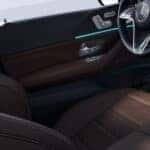Interior of a 2026 Mercedes-Benz GLE detailed view of the driver-side door panel and steering wheel.