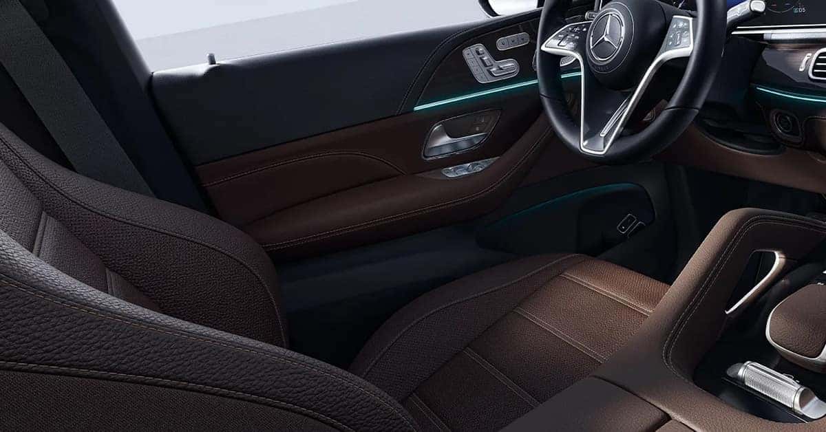 Interior of a 2026 Mercedes-Benz GLE detailed view of the driver-side door panel and steering wheel.