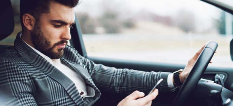 Man holding phone while in driver's seat